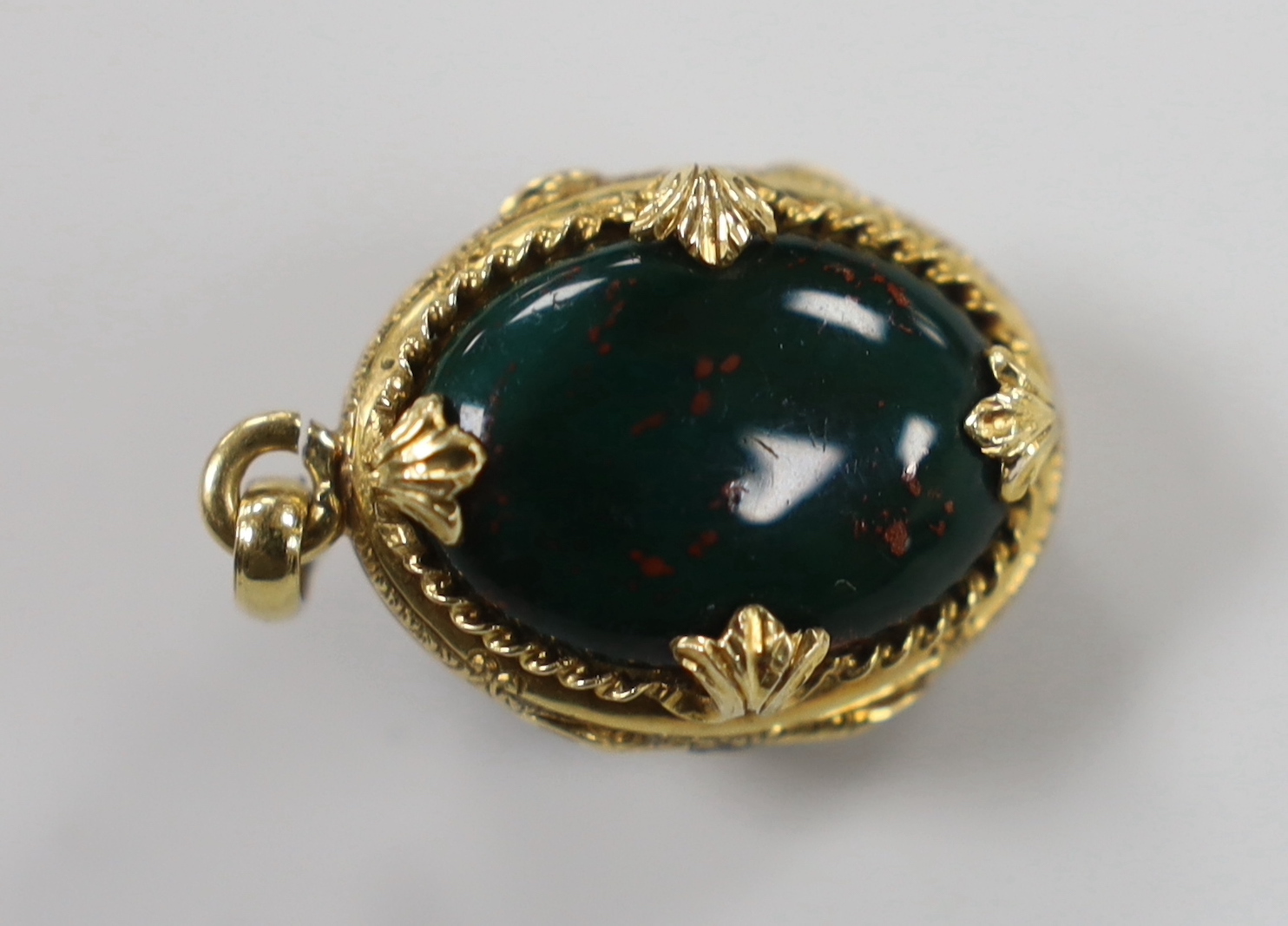 A 1940's? yellow metal and bloodstone set egg shaped mourning pendant, with rose cut diamond set star motif and plaited hair interior, overall 28mm.